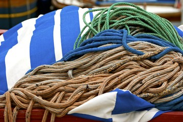 Bundles of mooring rope lies on striped cloth.