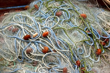 Heap of fishing nets and ropes on the quay.