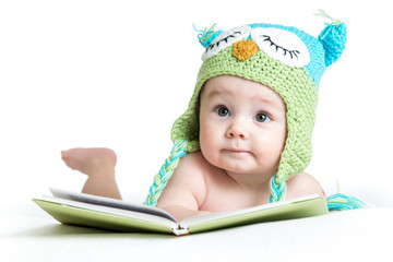 baby in funny knitted hat owl with book  on white background