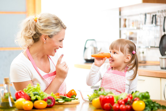 mother and child preparing healthy food and having fun