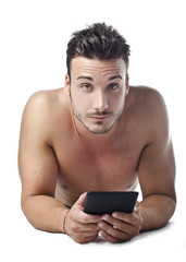 Fototapeta premium Handsome young man shirtless reading ebook on the floor