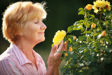 Expression. Senior Woman Model with Garden Roses. Springtime