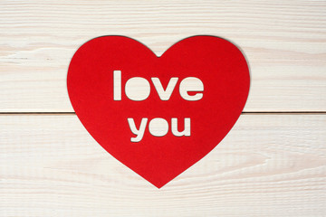 Heart cut from red paper with inscription  love you