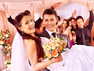 Groom  carries bride on his hands .