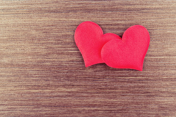 Fototapeta premium two red hearts on a wooden board