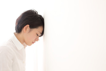 壁に寄りかかる女性