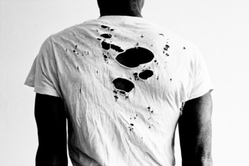 man's back with holy torn t-shirt