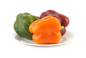 Three fresh sweet peppers on plate isolated close up