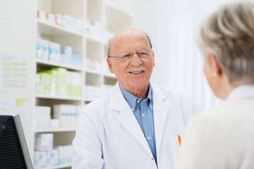 freundlicher älterer apotheker im kundengespräch