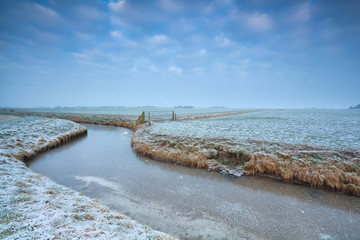 frozen canal on Dutch farmland