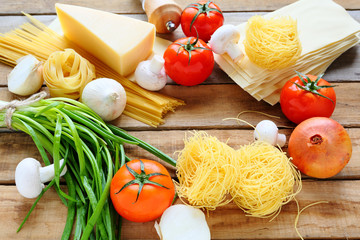 pasta with ingredients on wooden background
