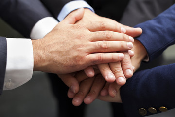 Businesspeople hands on top of each other as symbol of their uni