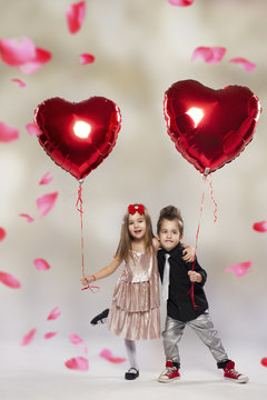 Happy kids with red heart balloon on a light background