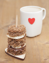 Canape biscuit with banana and walnut - chocolate cream. Cup of