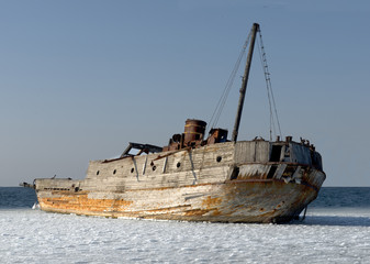 Fototapeta premium Old ruined-ship tossed on the sea shelf