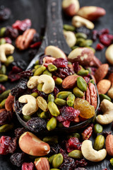 Nuts and dried fruits mix on wooden spoon