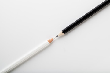 Fototapeta premium white pencil and black pencil placed on opposite color