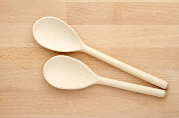 Two wooden spoons on a chopping board