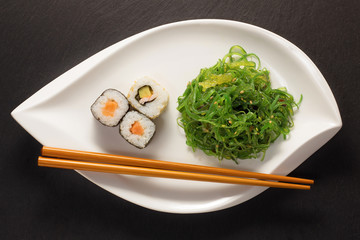 Algensalat mit Maki Sushi und stäbchen