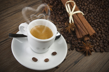 cup of coffee with heart of steam, cinnamon sticks and anise