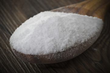 wood spoon of baking soda close up on table