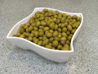 White bowl with green olives
