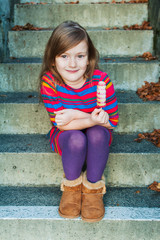 Outdoor portrait of a beautiful little girl with ice cream