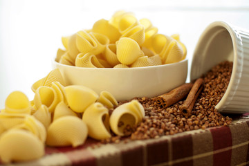 White porcelain plates with dry Snailshell-shaped pasta and buck