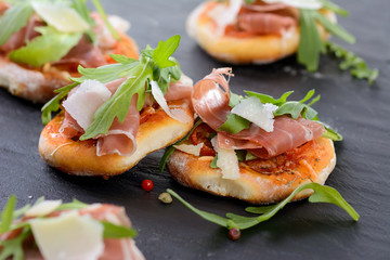 Pizza-Fingerfood mit Schinken und Rucola