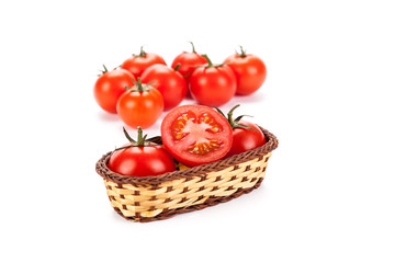 red tomatoes in a small basket on a white background