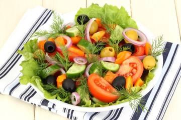 Fresh salad in plate on wooden table