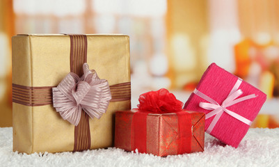 Gift boxes on rug on bright background