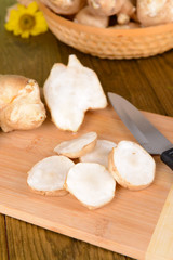 Topinambur roots on cutting board on table close-up