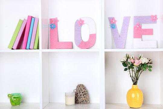 White shelves decorated with handmade knit word