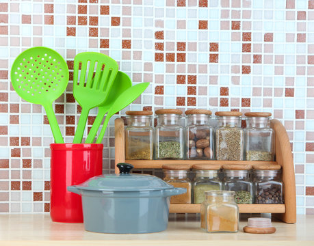 Set of spices, tableware and kitchen utensils in kitchen