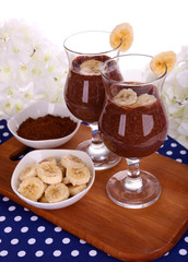 Cocktails with banana and chocolate on table on white