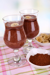 Cocktails with banana and chocolate on table on light