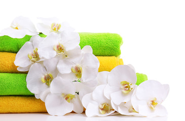 Fototapeta na wymiar Kolorowe ręczniki i kwiaty orchidei, odizolowane na białym