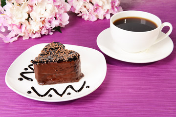 Sweet cake with chocolate on plate on table close-up
