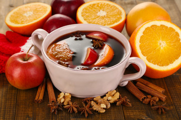 Fragrant mulled wine in pan on wooden table close-up
