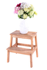 Vase with flowers on small wooden ladder, isolated on white