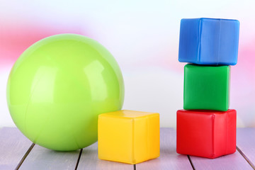 Bright ball and colorful  cubes on table on bright background