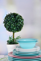 Clean dishes with flower on wooden table on natural background
