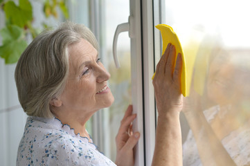 Senior woman cleaning window