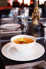 Bowl of pumpkin soup on table