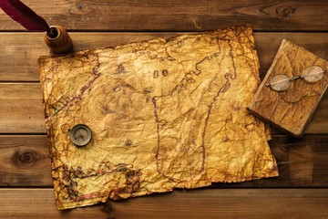 Vintage map, compass and book on wooden background