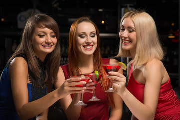three girls raised their glasses in a nightclub