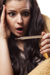 Obraz premium shocked sick girl looking at a thermometer