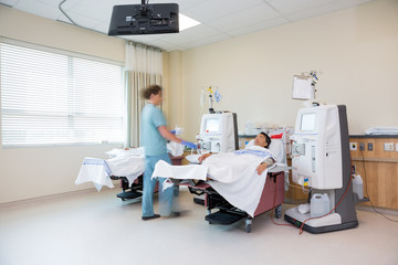 Nurse Walking By Patient Receiving Renal Dialysis