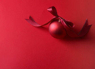 Red christmas ball, isolated on red background.